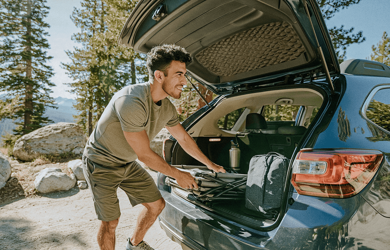 man loading car for a camping trip
