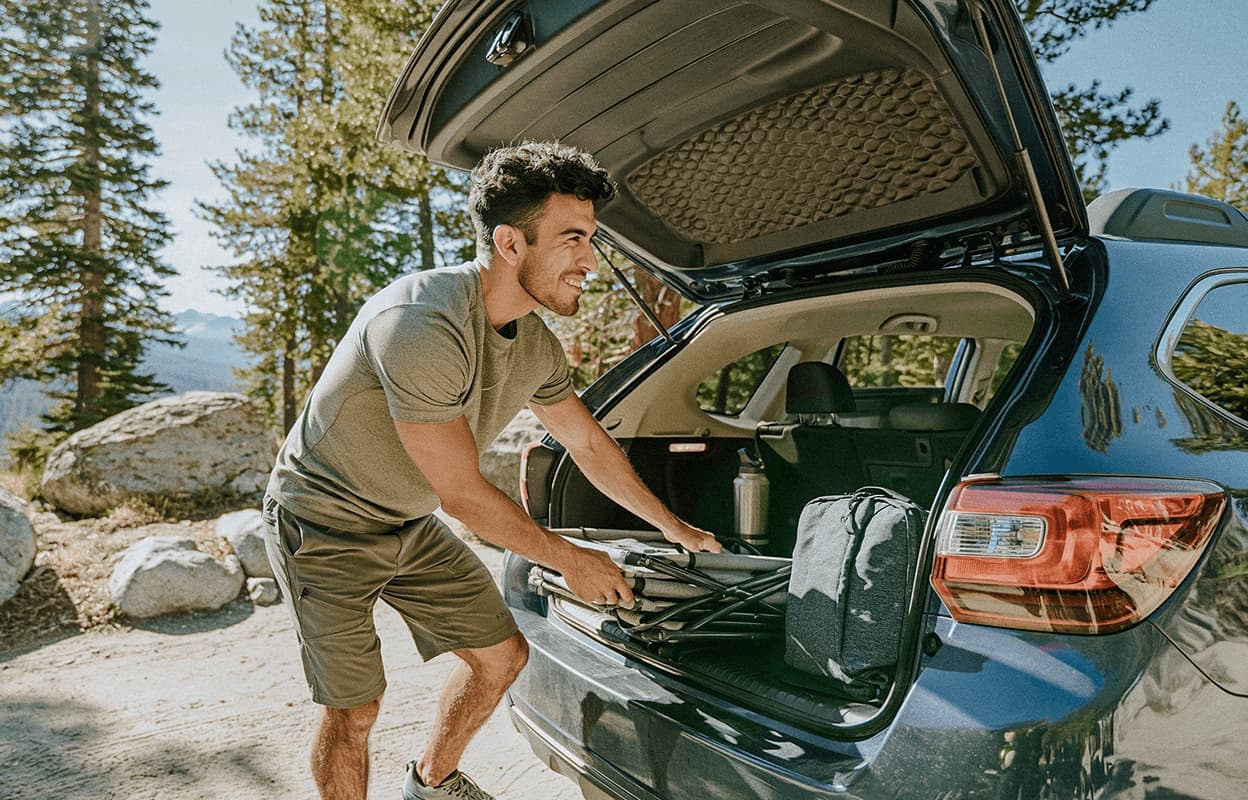 man loading car for a camping trip